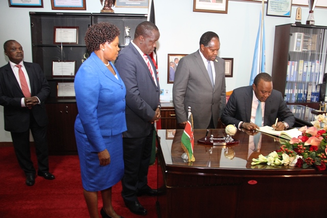 President Uhuru Kenyatta (sitted) signing the Visitors book during the official Opening of Nairobi Innovation Week. PS Prof Suda, Prof. Matiangi and VC Prof. Mbithi 2016