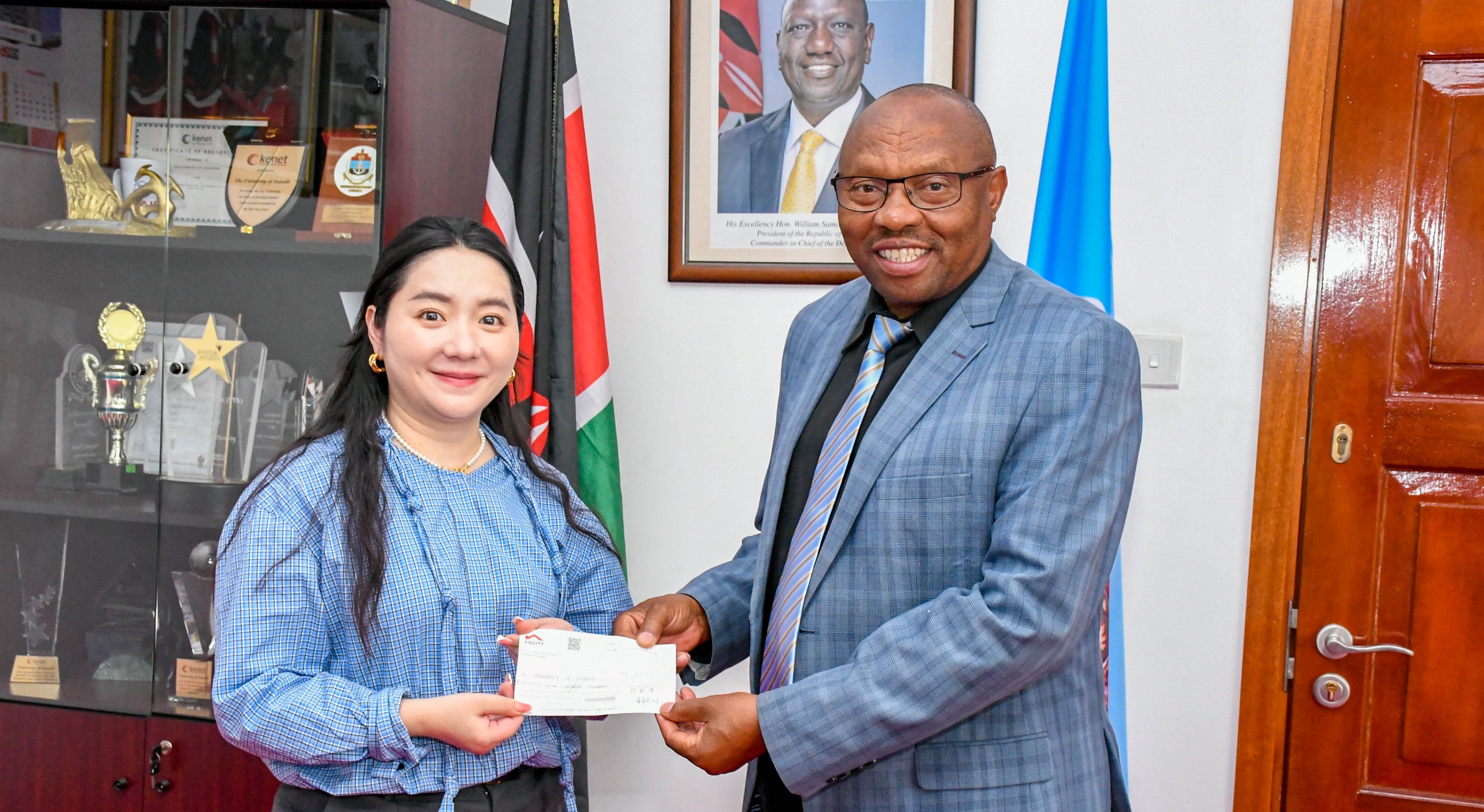 DVC FPD Prof Jackson Maalu receives the cheques from Chinese Property Developer Association (Kenya) Chair representative Ms Wen Hui.