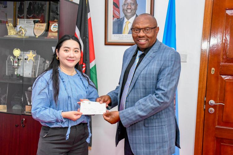 The DVC Finance Planning and Development, Prof Jackson Maalu receives the cheque donations from Chinese Property Developer Association (Kenya) Chair representative, Ms Wen Hui.)