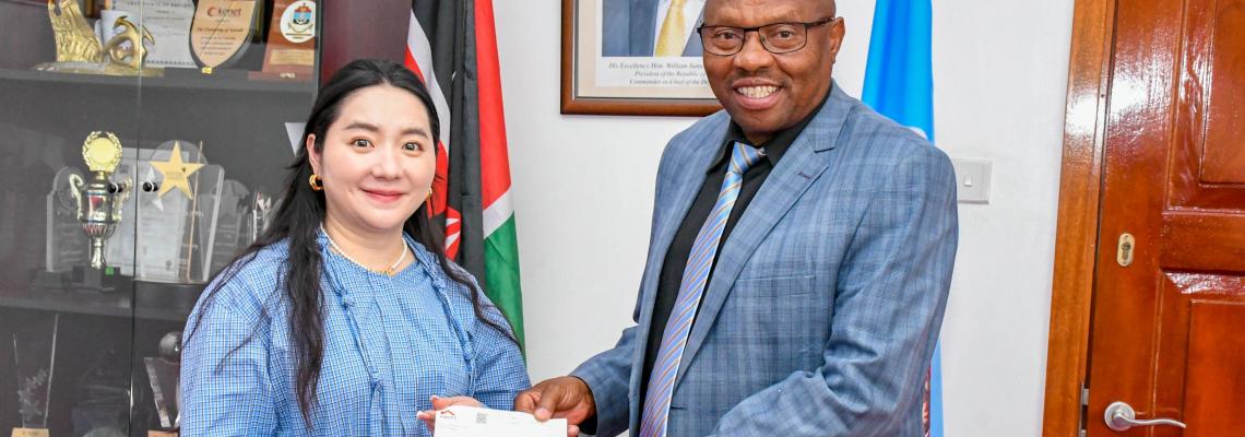 DVC FPD Prof Jackson Maalu receives the cheques from Chinese Property Developer Association (Kenya) Chair representative Ms Wen Hui.